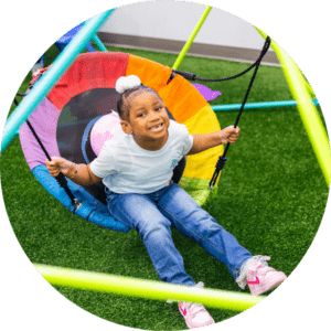Girl enjoying a sensory swing during ABA therapy at an ABLE Kids clinic.